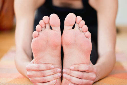 Woman in seated forward fold doing yoga for tight hips and knee injuries